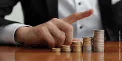 Geldstapel, der den Unterschied zwischen aktiven und passiven ETFs darstellen soll