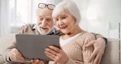 Sich um die private Altersvorsorge kümmern Das Bild zeigt 2 Senioren, die sich auf einem Tablet ihre private Altersvorsorge ansehen und sich darüber freuen